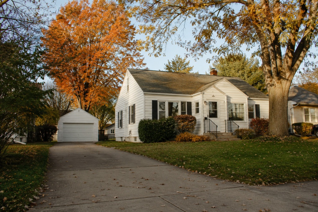A modest suburban Wisconsin home on a tree-lined street in autumn, where property taxes shape the monthly payment.